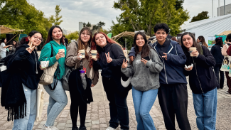 Estudiantes de la Usach mostrando los regalos institucionales por su participación en la Feria Usach Sostenible 2025.