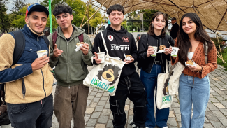 Estudiantes de la Usach mostrando los regalos institucionales por su participación en la Feria Usach Sostenible 2025.